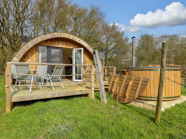 A cabin with a deck and hot tub at Grape Escape near Halesworth