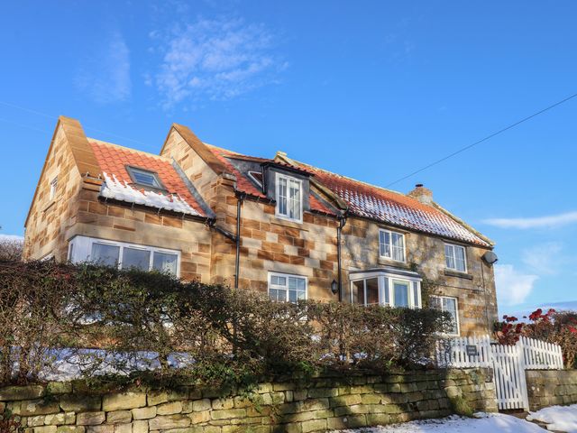 A house with hedges and a fence at Cheyne Cottage in Fylingthorpe