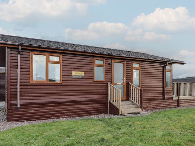 A log cabin with windows and a sign at Colonsay