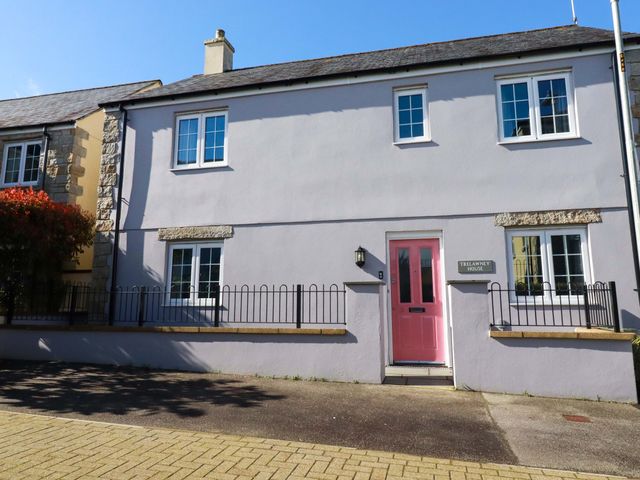 A house with a pink door and sign at Trelawney House in St. Austell
