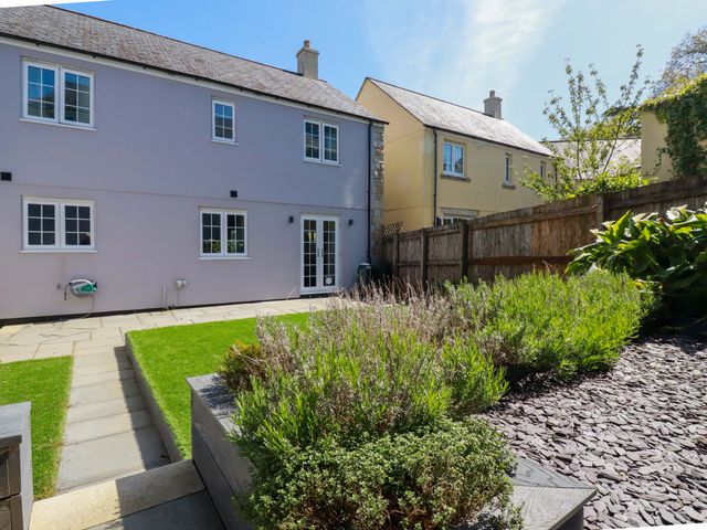 A garden with a house and pathways at Trelawney House Duporth near Charlestown