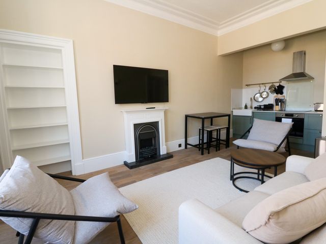 A living room with a sofa and armchair at Flat 1