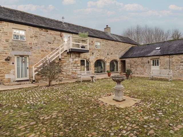 An outdoor area with stone building and fountain at The Classic in Hexham