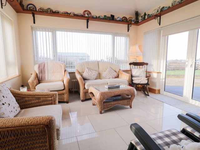 A conservatory with seating and a table at Storey and Half House in Annagry