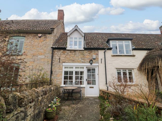 A cottage exterior with a table and chairs at Stones Bakery in Wedmore
