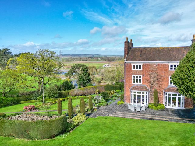 A garden with a house and landscaping at The Mill House in 