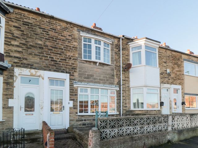 An outdoor view of residential houses with doors and windows at Cattersty Cottage
