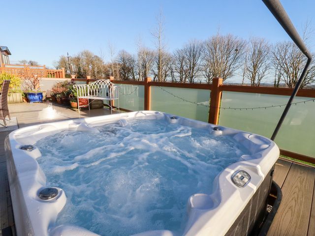 A hot tub surrounded by seating and plants at FW4 (Fairways 4) Doublebois near Dobwalls