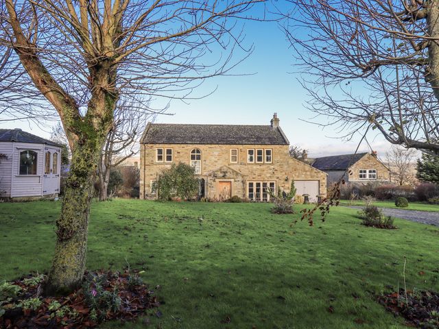 A house with a garden and trees at Orchard House in Leyburn
