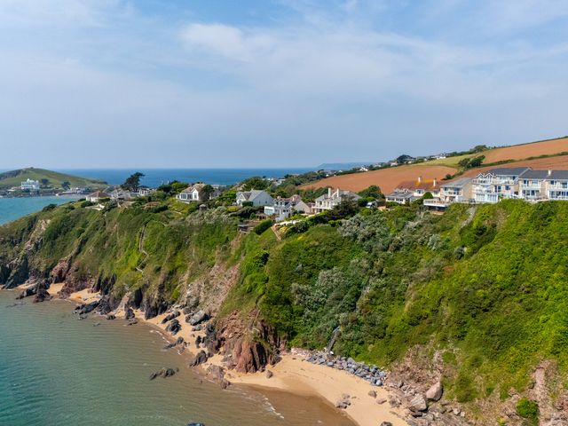 A scenic view of houses on a cliff by the ocean at 6 Avon Quillet Bigbury-On-Sea