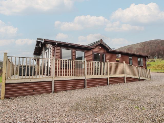 A wooden cabin with decking located outside at Monach 2 in Fort William