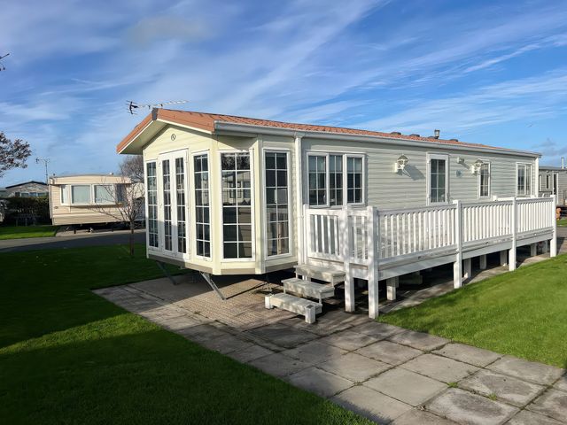 A mobile home with a deck and steps at Gainc Bach in Abergele