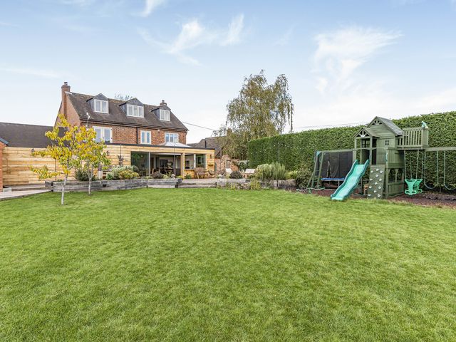 A garden with a slide and swingset at 2 Mere Pits Cottages in Tamworth