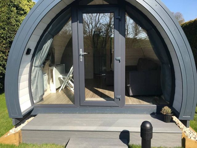 A pod structure with a front door and seating at Pod 1 (Pet Friendly) in Carnforth