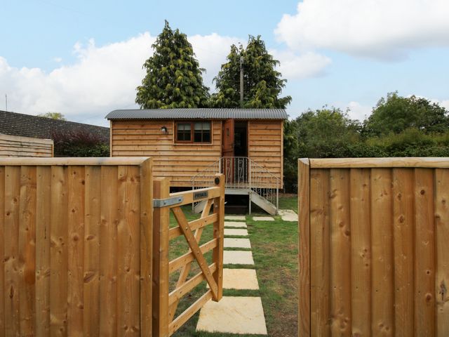 A wooden cabin with a pathway in the garden at Woodie in Clee Hill