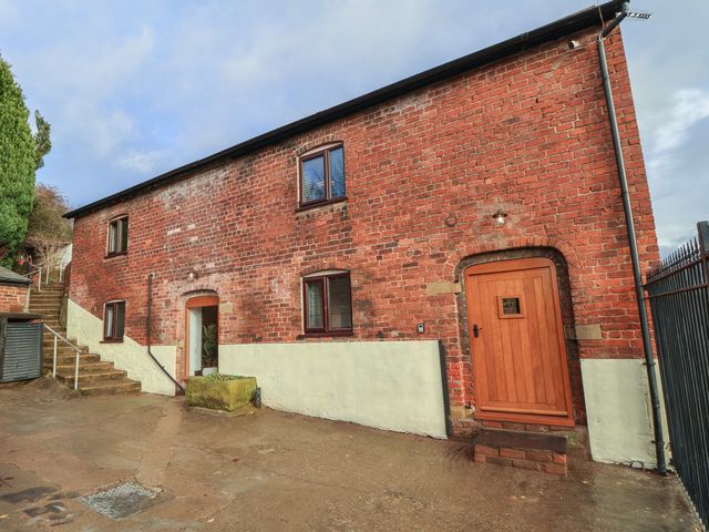 A brick building with windows and a door at Quarry Barn in Wrexham