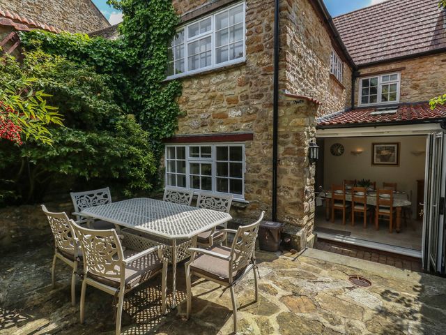 A garden with a stone table and chairs at Crantock