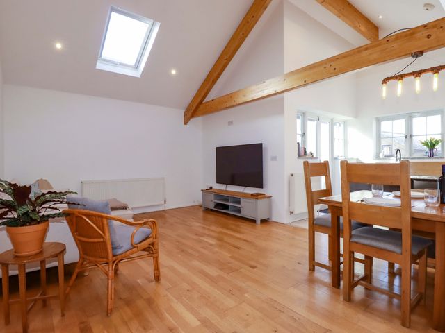 A living room with a sofa, table, and television at The Maisonette Hayle