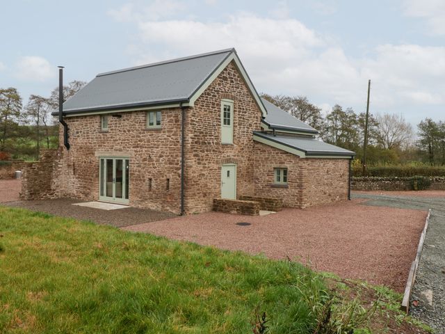 A house with stone exterior and yard at Velindra Farm Cottage in Hereford