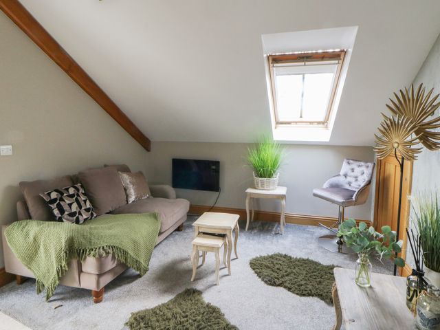 A living room with a sofa and coffee table at Rose Apartment in Oldwalls near Reynoldston