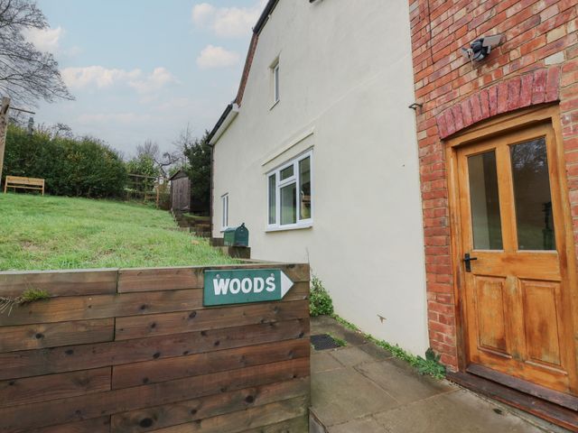 An outdoor view of a house with a door and sign at The Woods