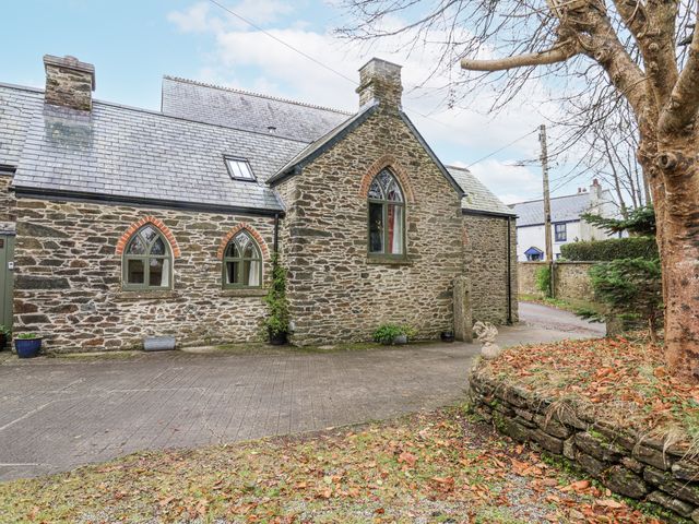 Exterior view of a stone house with windows and a driveway at Flagstaff Cottage
