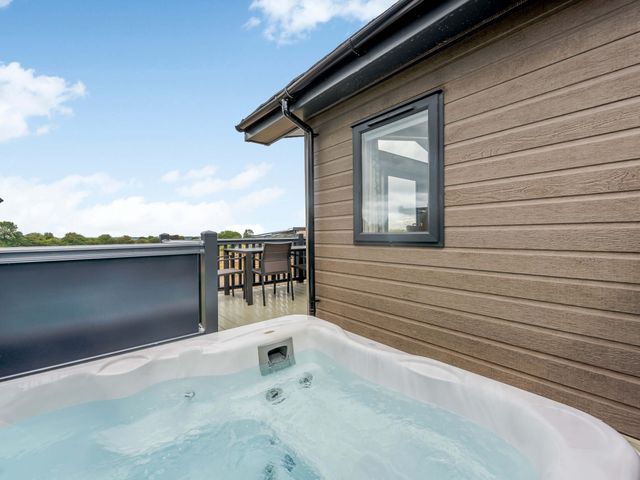 A hot tub on a deck beside a house at Helvellyn in Penrith