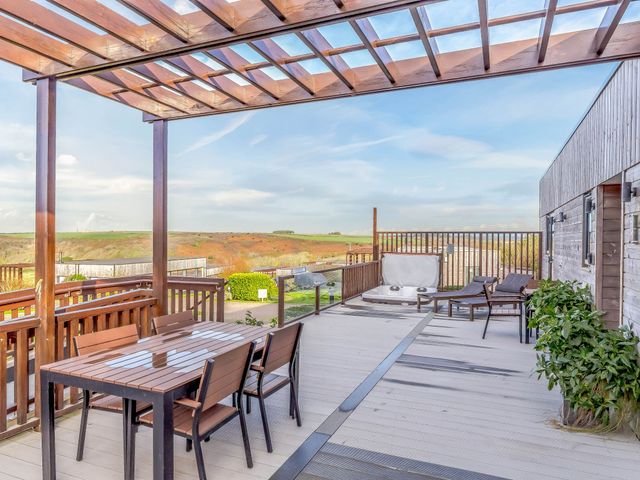 An outdoor area with a table and chairs under a pergola at Signature Assisted Living Pet Portreath
