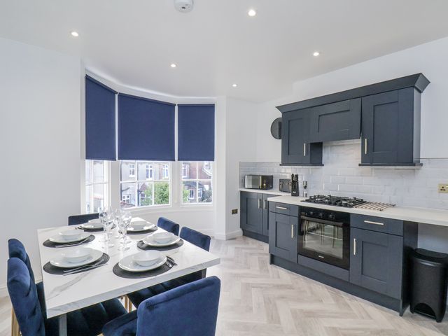 A kitchen with a dining area and modern appliances at 2 bed Scarborough