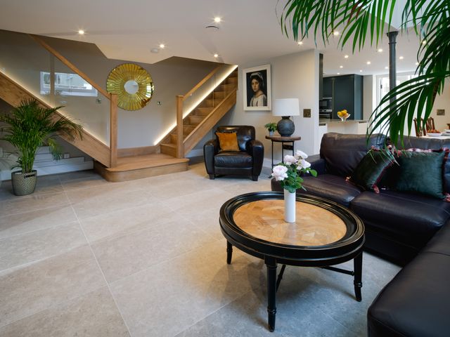 A living room with a staircase and furniture at The School House in Newton Abbot