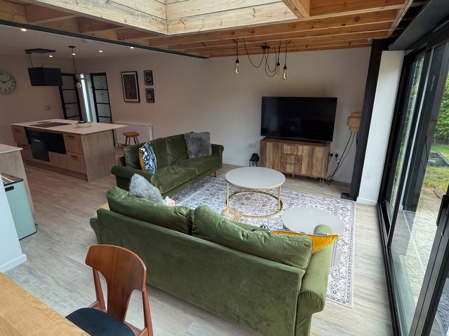 A living room with a sofa and television at 81 Lon Gogarth Benllech