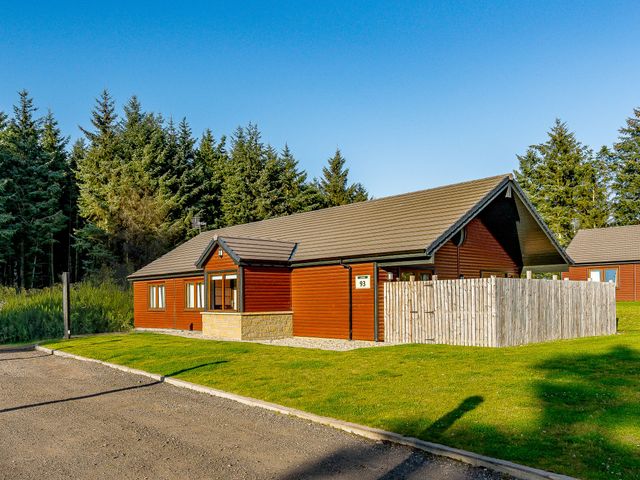 A cabin with windows and a fenced area at Galbraith Premier Spa in Dundee