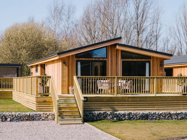 A wooden log cabin with a deck at The Luxury Escape in Waltham