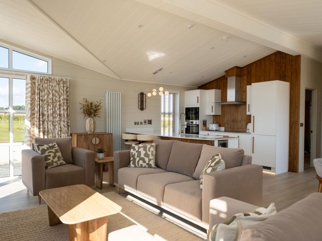 A living room with a sofa and kitchen in Exclusive Aura Spa Waltham