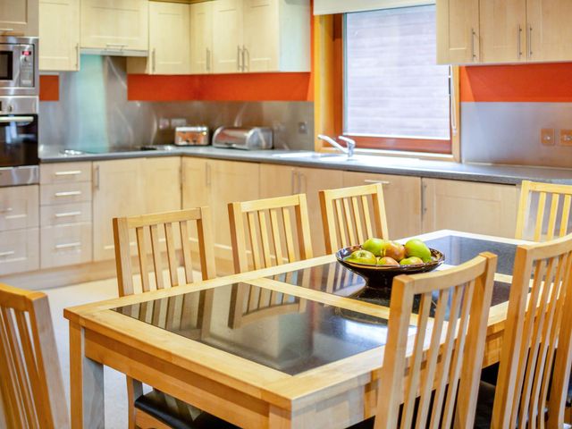 A kitchen with a dining table and chairs at Woodland Lodge Spa in Praze-An-Beeble