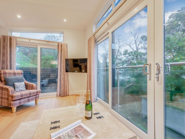 A living room with a chair and a table at Milk Wood 2 in Laugharne