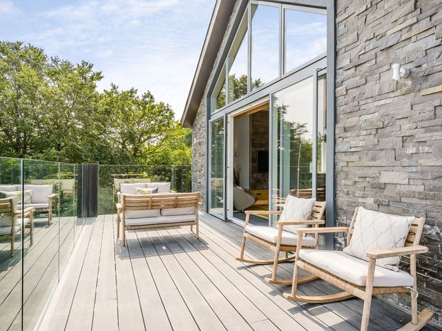 An outdoor deck with rocking chairs and a sofa at The View in Laugharne