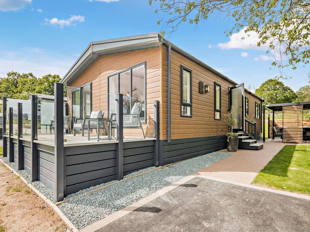 A house with a deck and chairs at Saron 2.0 Spa Pet in Llandyrnog