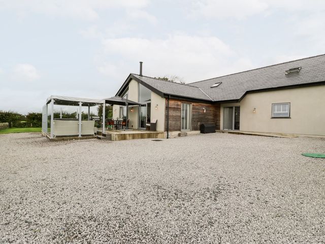 A house with a patio and outdoor seating at Cae Sam in Pentraeth