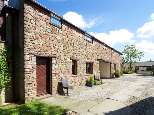 A stone building with a pathway and chairs at Skiddaw in Penrith