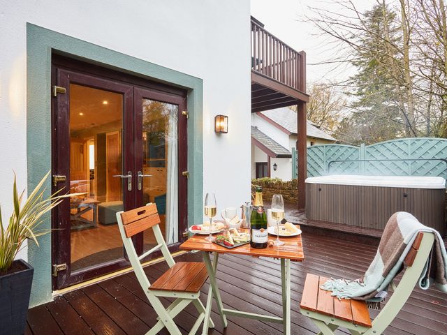 An outdoor area with a table and chairs beside a hot tub at The Troutbeck Den Spa in Penrith