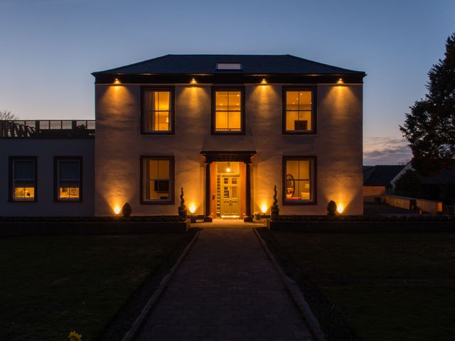 A house with illuminated windows and a pathway at The Farmhouse 2 Penrith