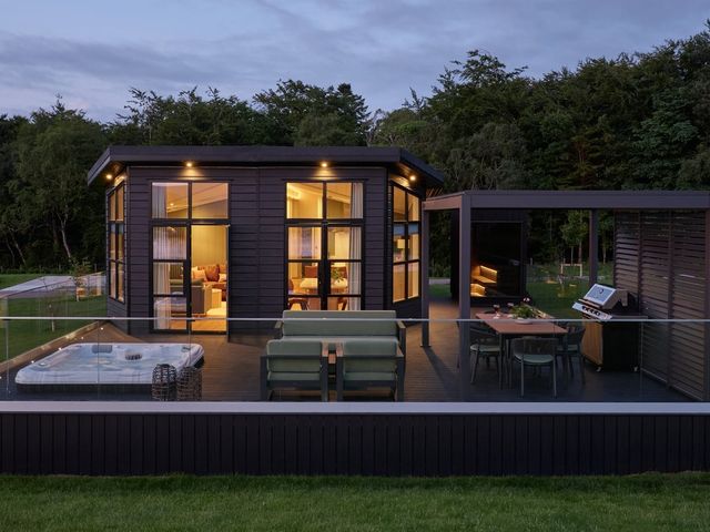 An outdoor area with a hot tub and dining table at Wansfell in Penrith