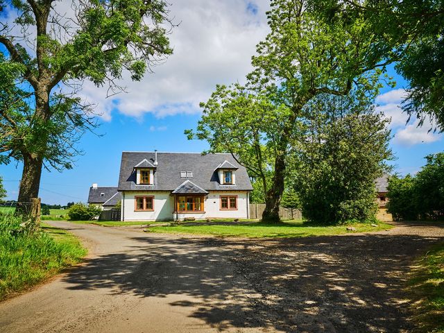 A house surrounded by trees and grass at Holly House in Blairgowrie