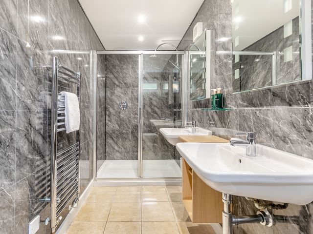 A bathroom with sinks and a shower at Tremewan Spa Pet Perranporth