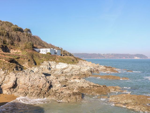 A coastline with rocks and a building at The Old Signal House in Torpoint