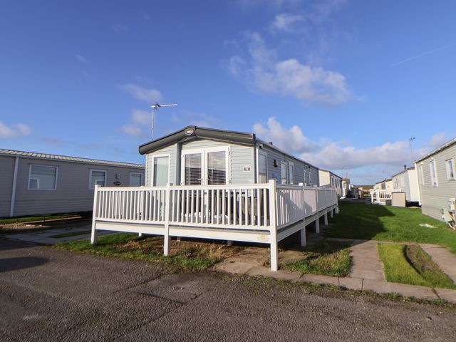 A mobile home with a deck and grass area at CG 55