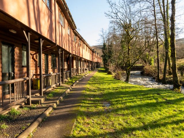 An outdoor area with cabins along a pathway and a stream at 3-bedroom cabin (3 of 13) Port Talbot