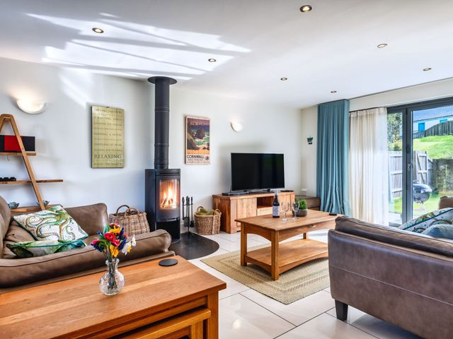 A living room with a fireplace and television at Venners in Marhamchurch