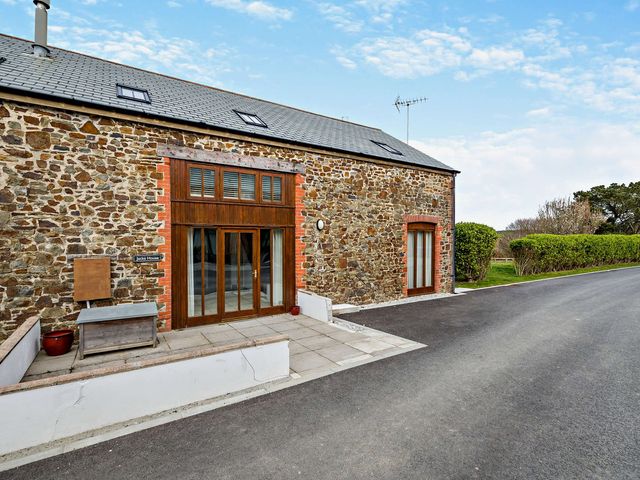 An entrance area with stone walls and pathway at Jack's House in Marhamchurch